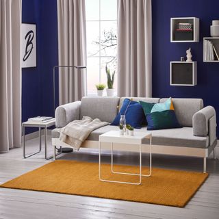 room with blue wall and grey sofa
