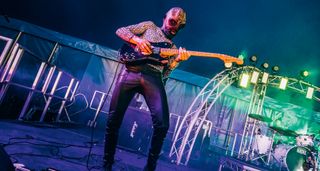 Squid Pisser's Tommy Meehan wears an alien mask and shreds on a black Telecaster