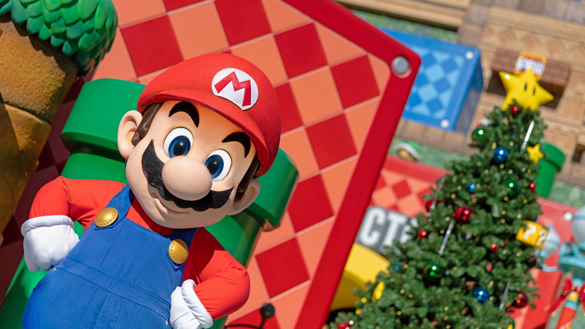 Mario standing next to a Christmas tree inside Super Nintendo World at Universal Studios Hollywood.