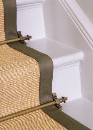 picture of stairs with stair rods and carpeting