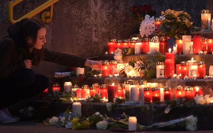 A mourner lights a candle.