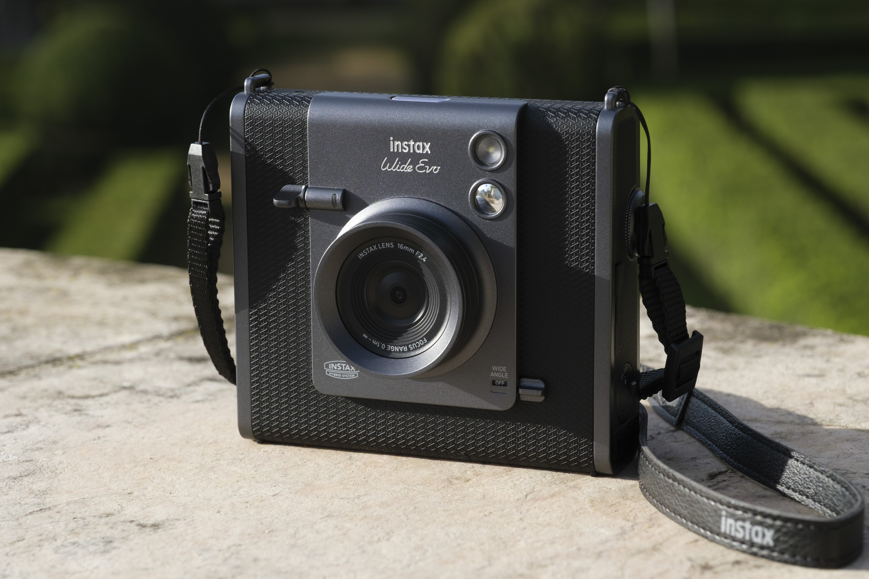 Fujifilm Instax Wide Evo instant camera outdoors in the sun on a stone surface
