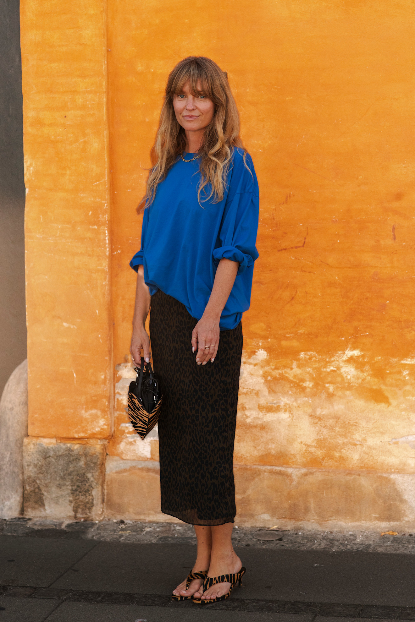 Woman in a blue top and leopard print skirt