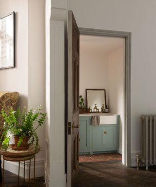 doorway leading to scullery with blue cabinets and tiled flooring