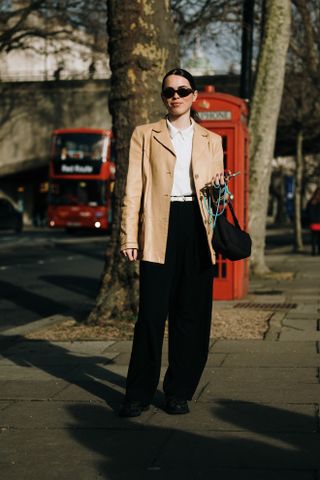 woman wearing leather jacket, white top, trousers, and boots