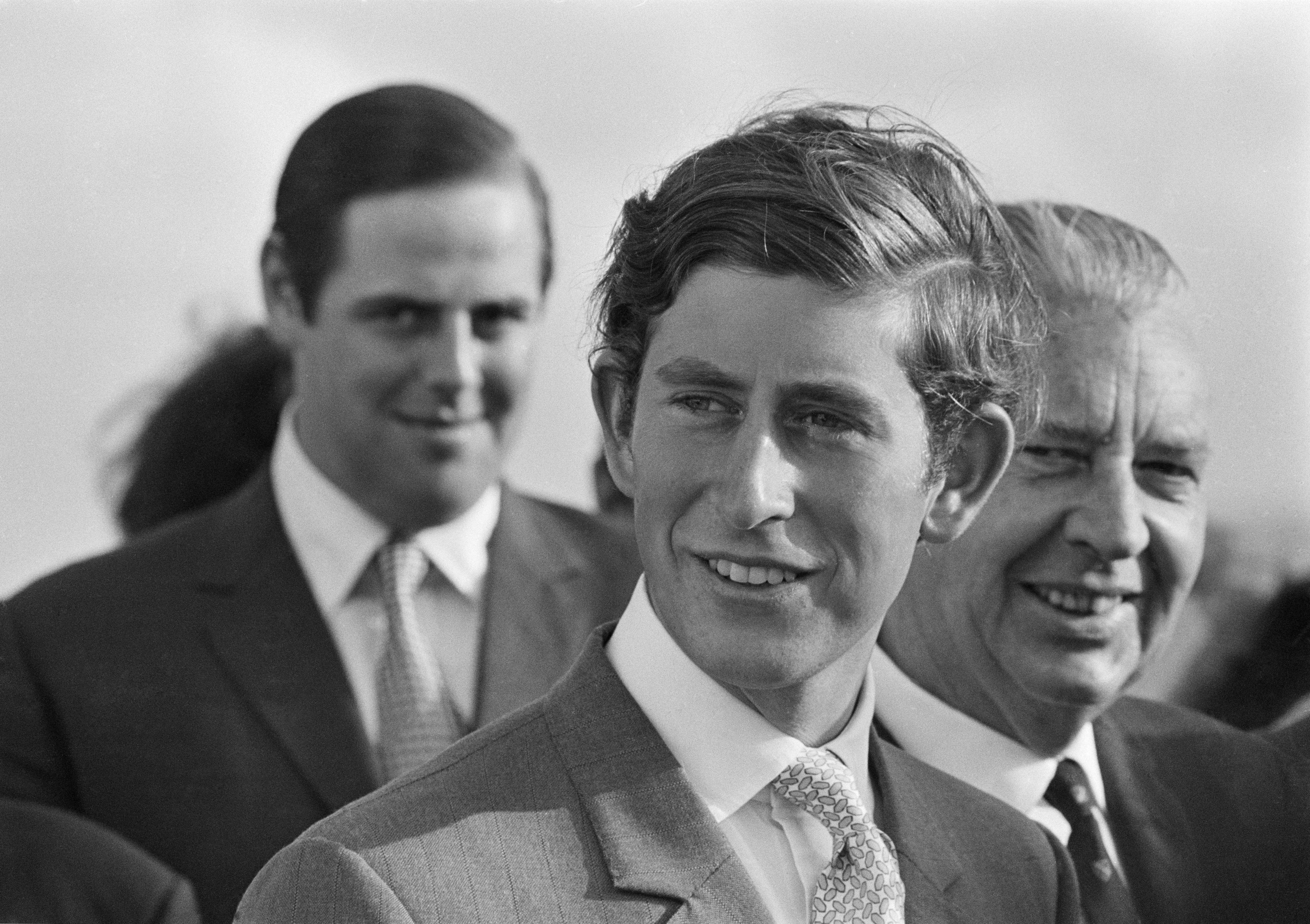Prince Charles wearing a suit and tie and smiling in 1970