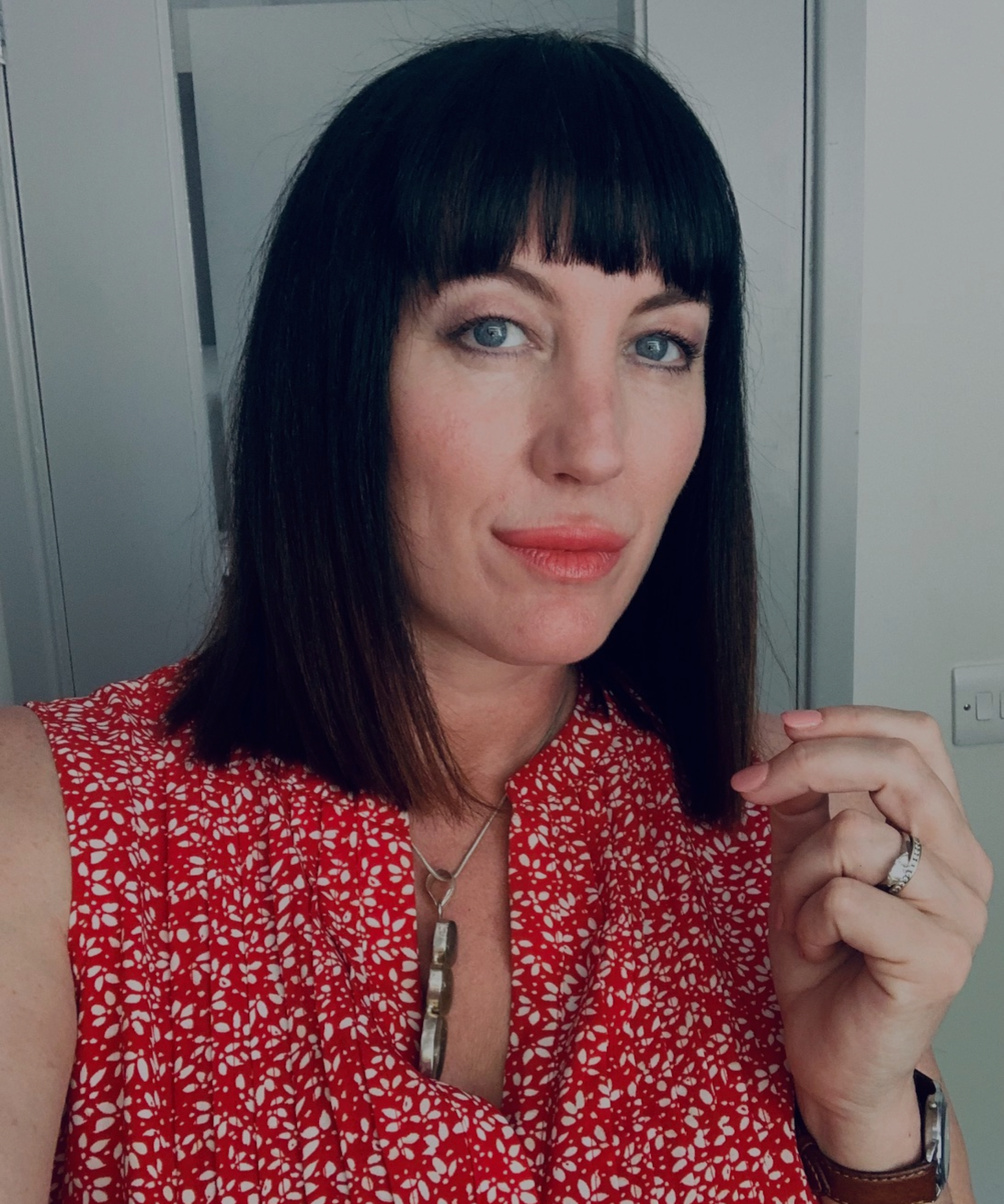 headshot of female with black bob wearing red blouse