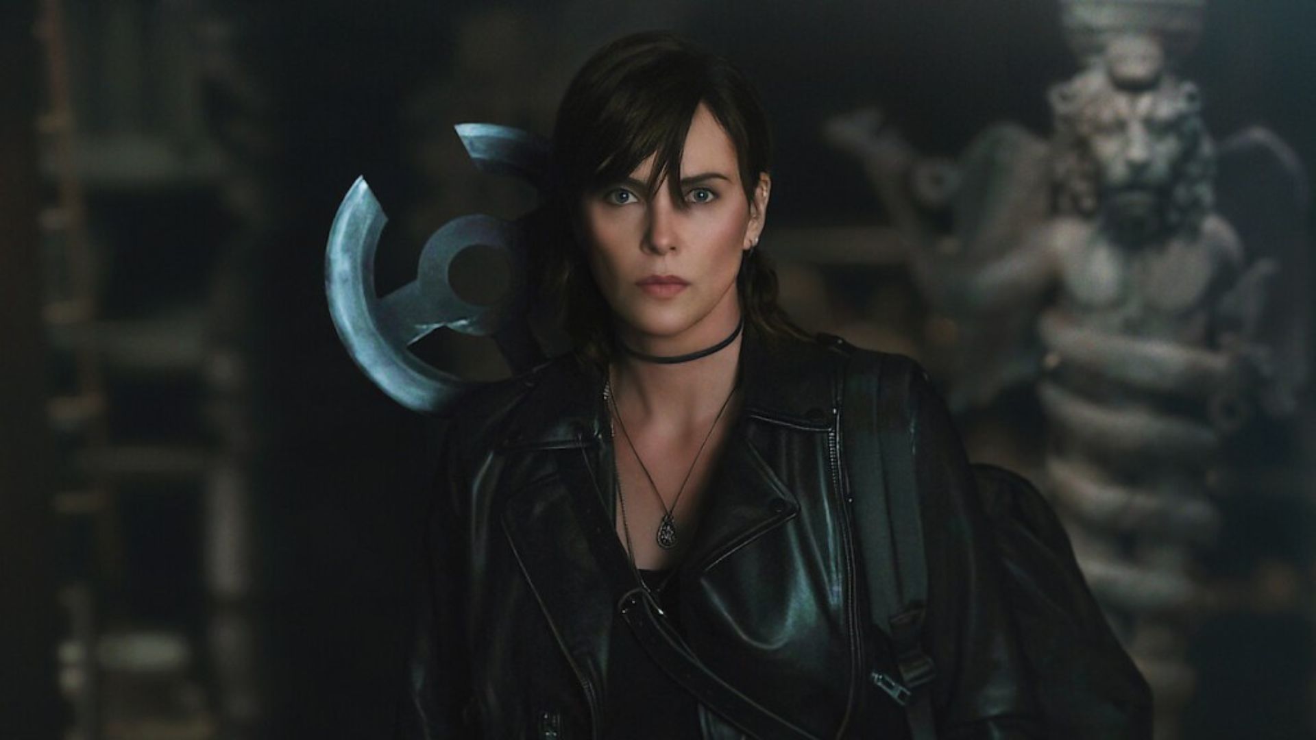Charlize Theron wields a circular sword behind her back in The Old Guard 2. 