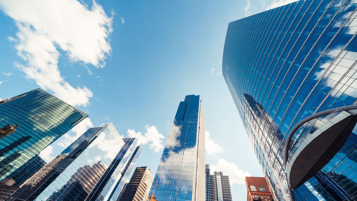 Skyscrapers viewed from below with clouds in the sky above