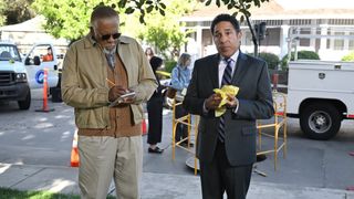L-R: Barry (Duane Shepard Sr.) and Oscar (Oscar Nunez) standing on a street in a scene from Peacock's The Office" spinoff, "The Paper"