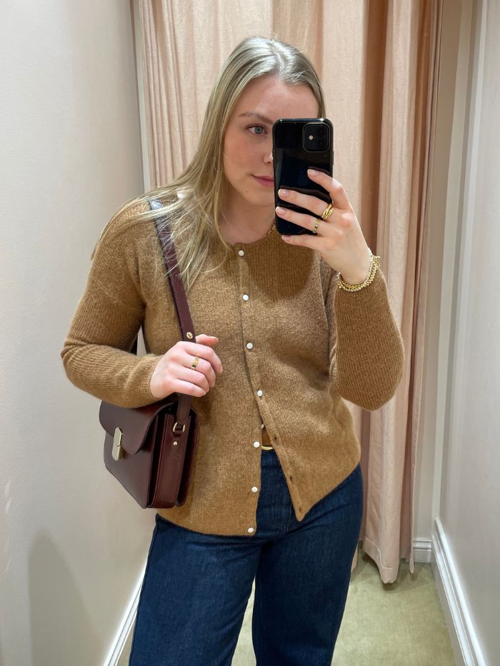 Woman wears beige camel cardigan from Sezane and blue jeans
