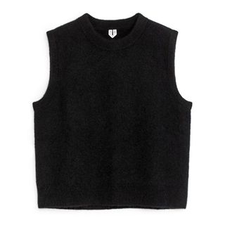 Cut out of a black knitted sleeveless jumper on a white background