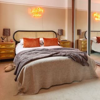 Light beige and rustic coloured bedroom, hanging neon lights above headboard