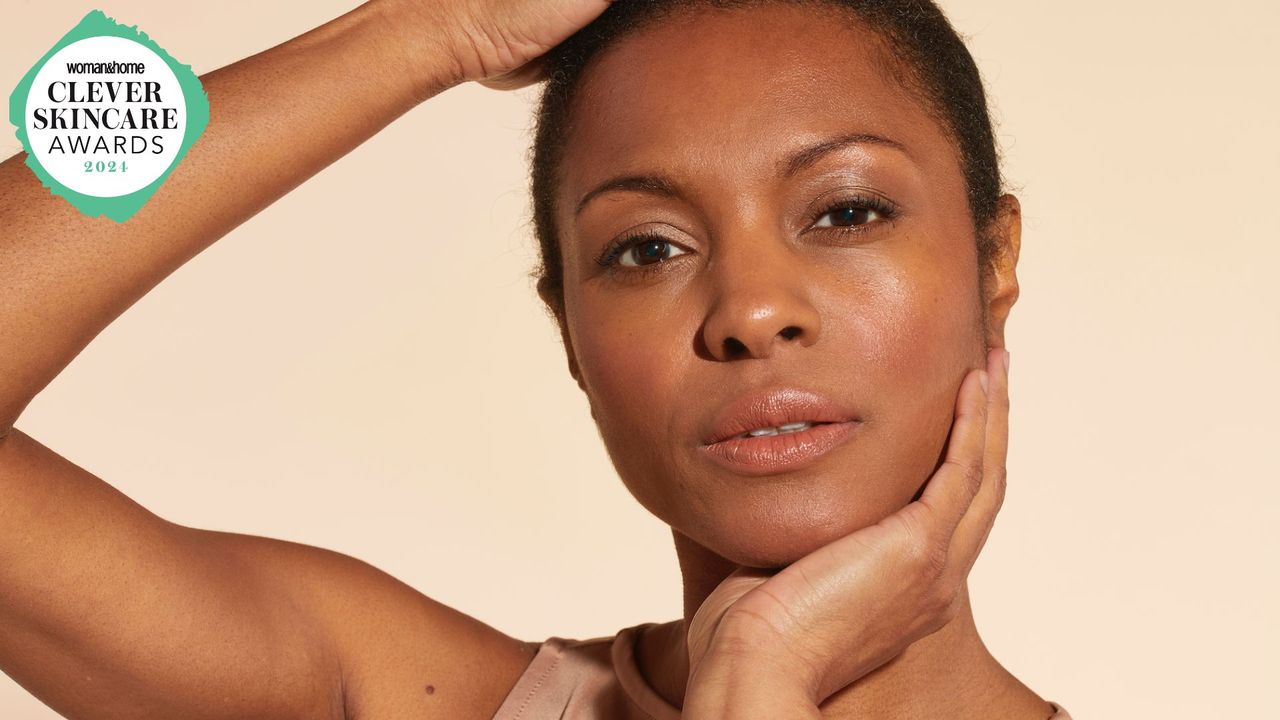 An image of a woman with her hands holding her face with the woman&amp;home skincare awards logo