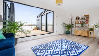 Living space with balcony view and blue and white rug