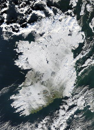 Lacy clouds encircled Ireland a few months ago on December 22, 2010, while a heavy covering of snow lay upon the land. NASA's Terra satellite used its Moderate Resolution Imaging Spectroradiometer (MODIS) instrument to capture this true-color image of the