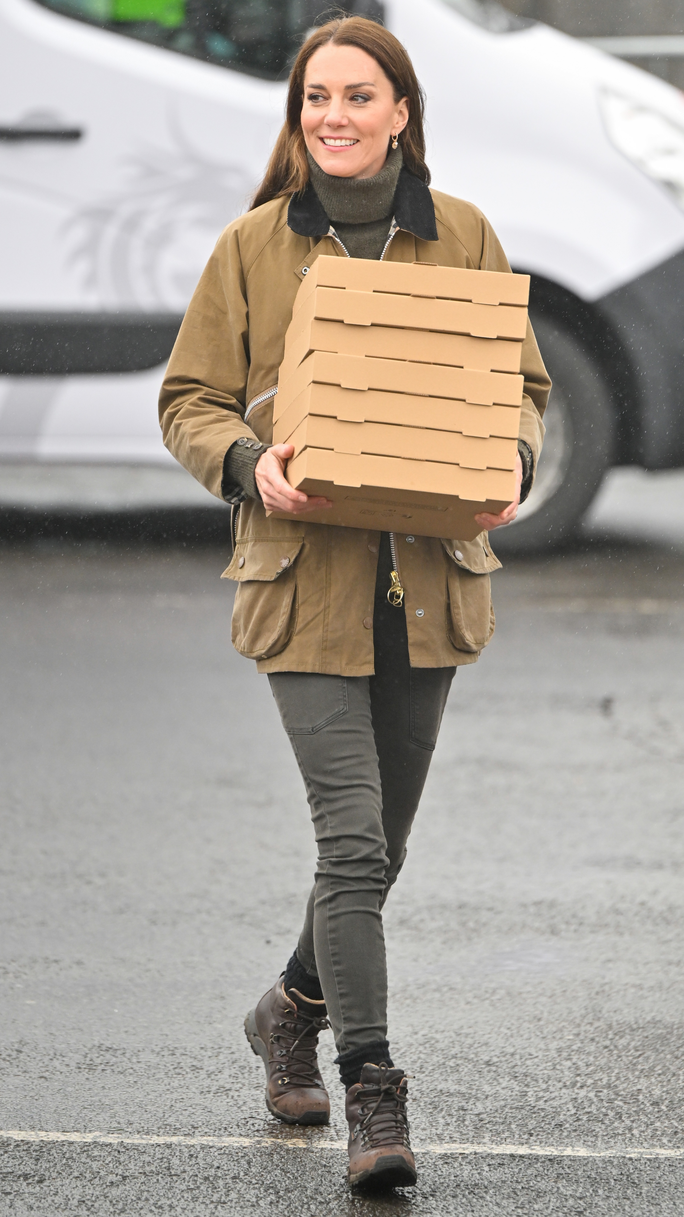 Catherine, Princess of Wales smiles carrying pizza boxes at Dowlais Rugby Club during a 2 day visit to Wales on April 27, 2023