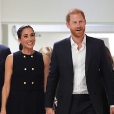 Prince Harry and Meghan Markle holding hands walking