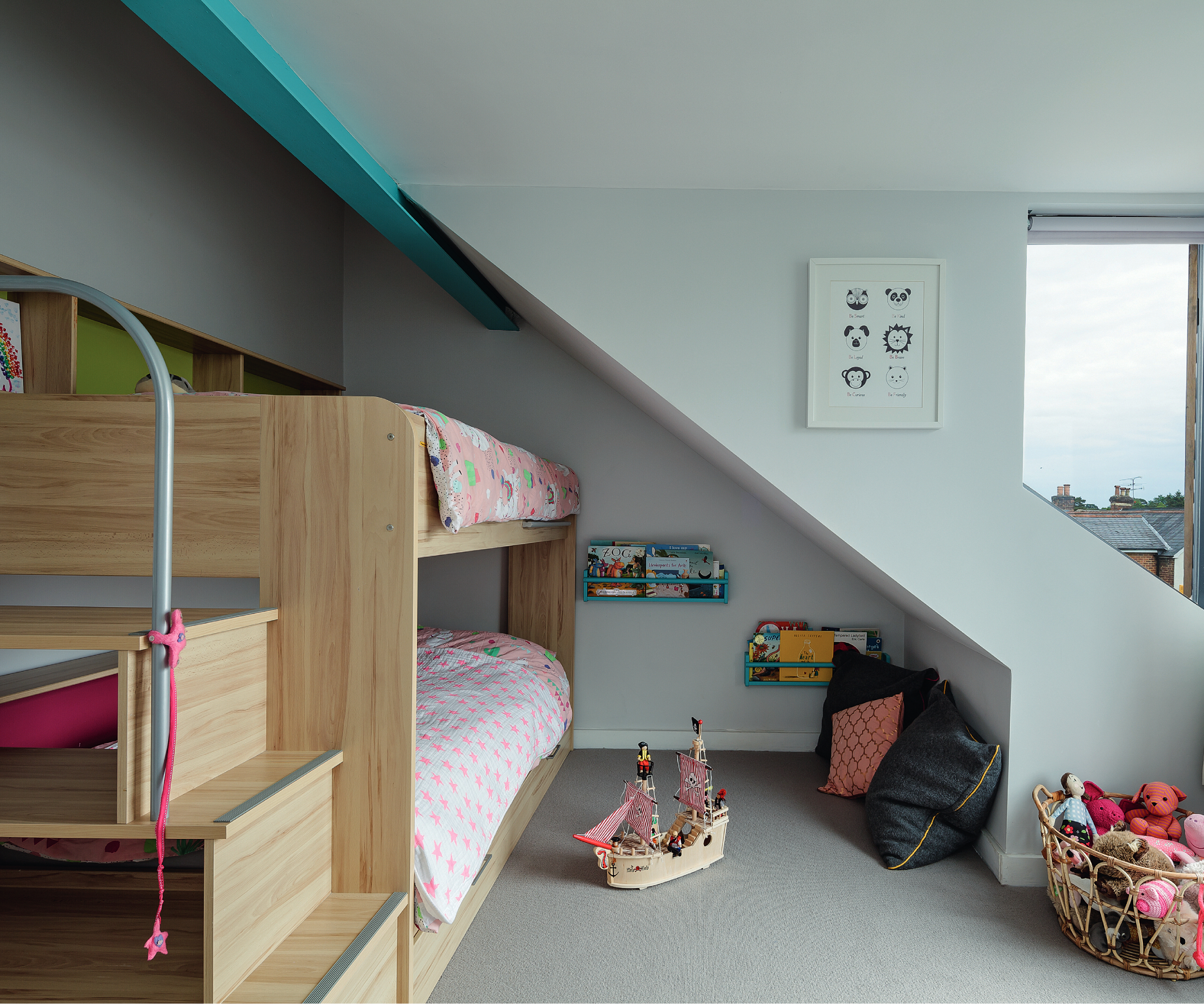 wooden bunkbeds under sloped section of roof in loft conversion