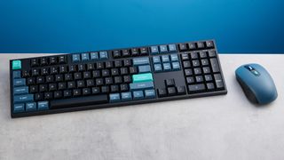 Keychron B36 keyboard and Keychron BM25 mouse photographed in front of a blue background. 