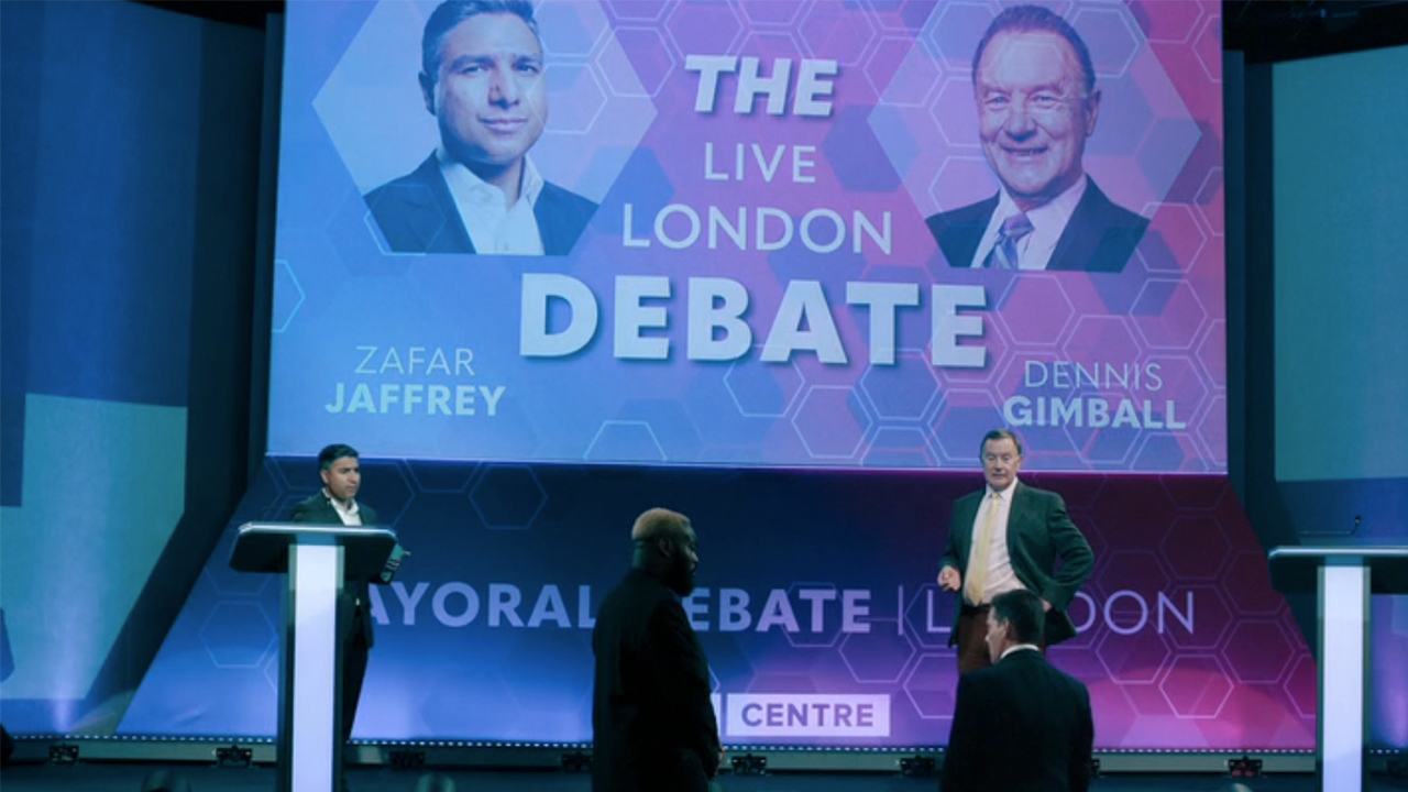 A debate stage in Slow Horses Season 5 with the candidates at their podiums.