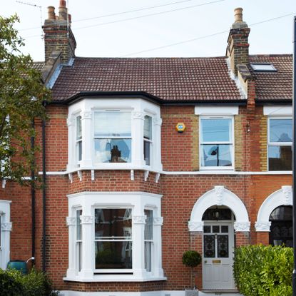 house with brick wall and white windows