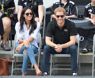 A photo of Meghan Markle sporting a white button-down shirt and skinny jeans at the 2017 Invictus Games.