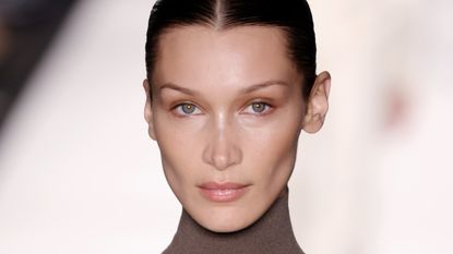 Close-up of Bella Hadid walking the runway at the Max Mara fashion show during the Milan Fashion Week Fall/Winter 2022/2023 on February 24, 2022 in Milan, Italy to signify the Bella Hadid face tape trick