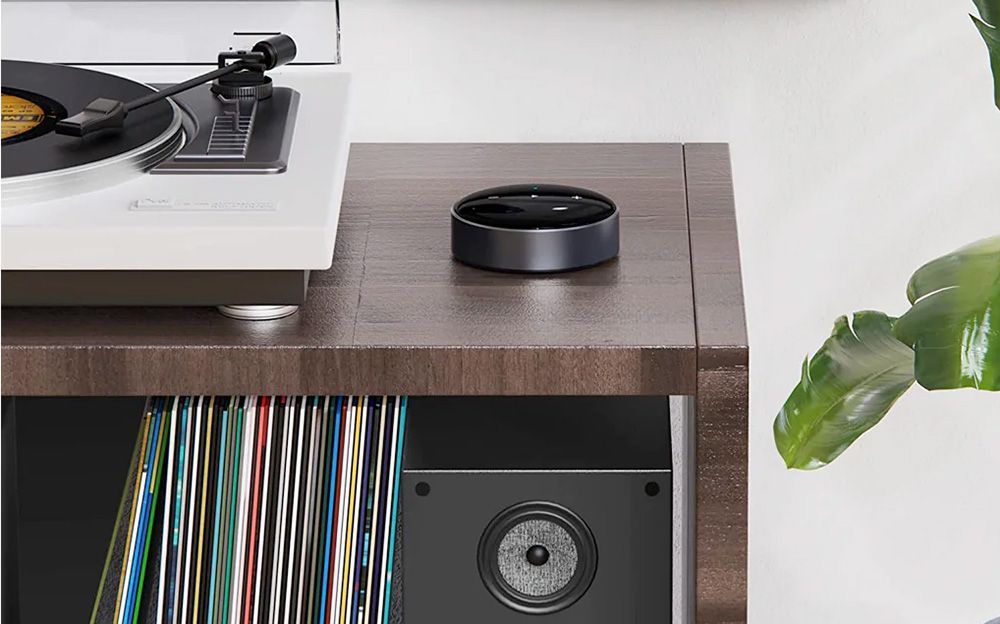 WiiM Mini on a desk next to a turntable, with a speaker below