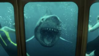 A shark swims towards a window with open jaws in 47 Meters Down: Uncaged.