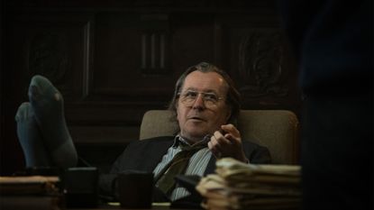 Gary Oldman relaxes with his feet up on the desk in Slow Horses on Apple TV+