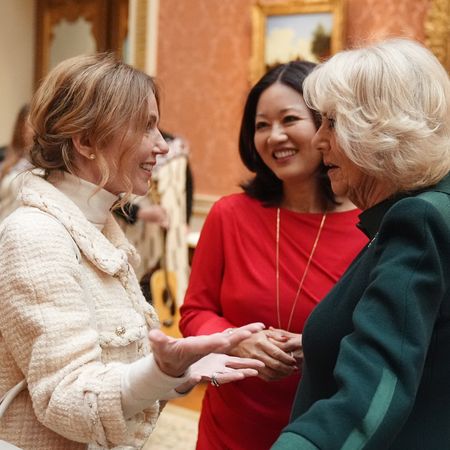 Queen Camilla talking to Geri Horner as a woman in a red dress looks on 