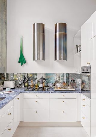 a high gloss kitchen with mirrored splashback