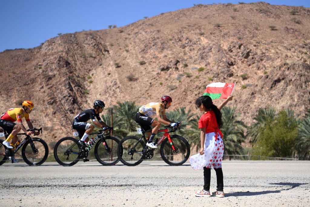 A girl waves a flag at the Tour of Oman