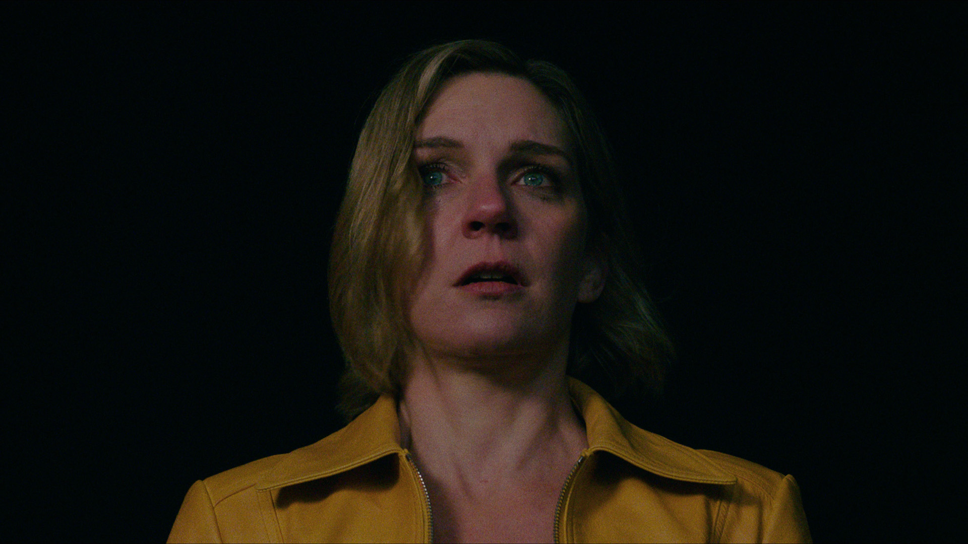 Rhea Seehorn as Carol Sturka, looking scared, in Pluribus.