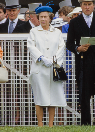 Queen Elizabeth The Queen Mother (1900-2002), Queen Elizabeth II and the Queen's racing manager Henry Herbert, 7th Earl of Carnarvon (1924-2001) on Derby Day at Epsom racecourse in Surrey, England, 5th June 1986