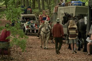 Mackenzeie Davis as Kirsten in Station Eleven, on horseback going through a caravan