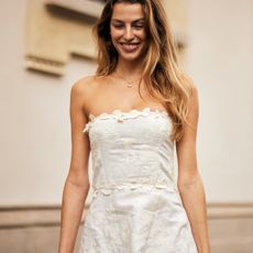 blonde fashion week attendee smiling wearing strapless white dress