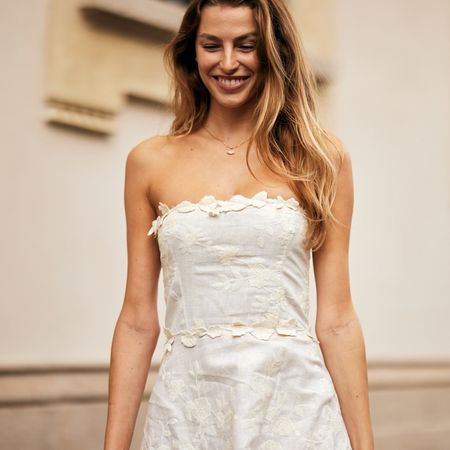 blonde fashion week attendee smiling wearing strapless white dress