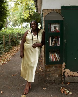 Plus size woman wears a silk slip dress and brown flat sandals in London.