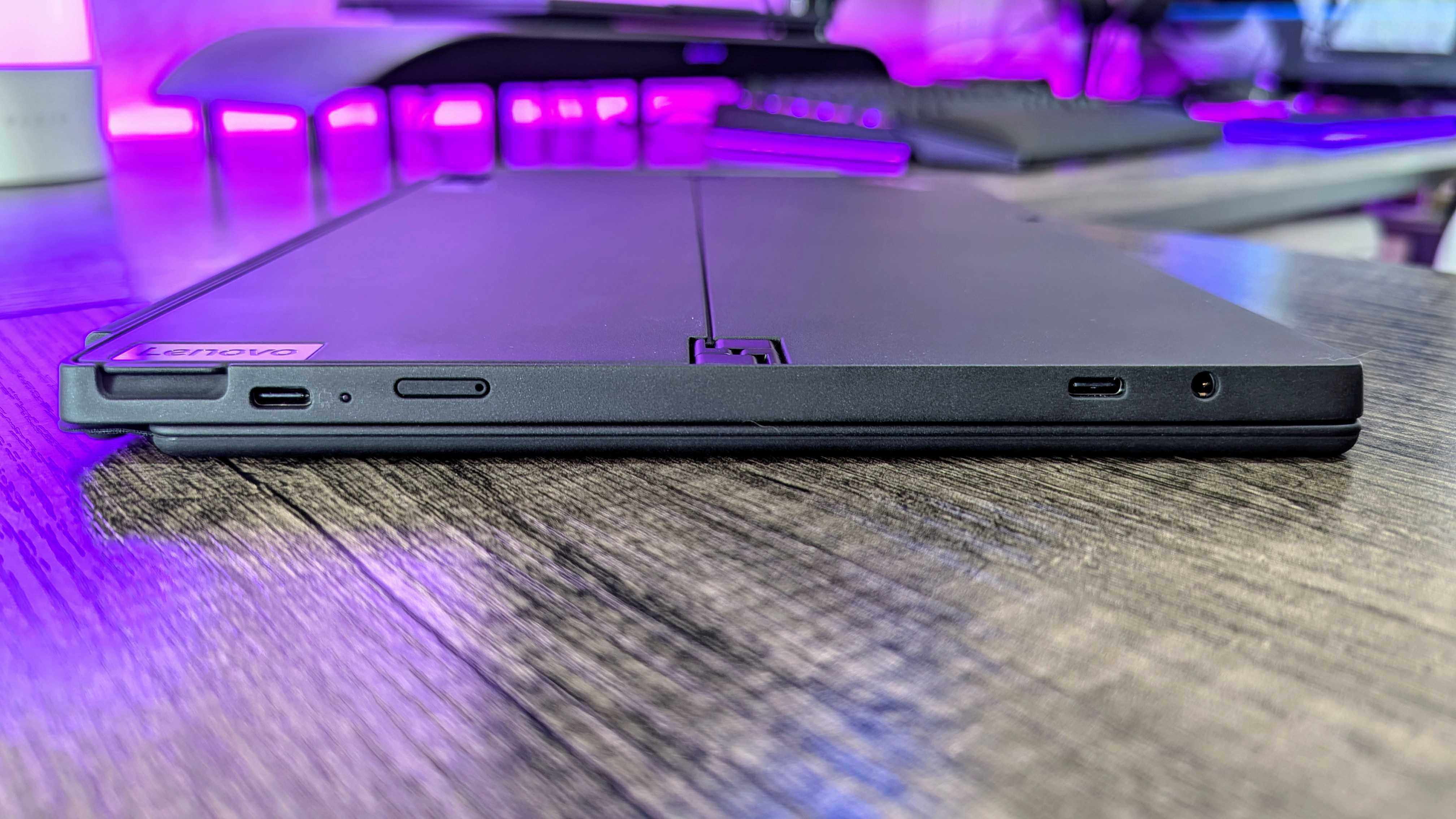 The Lenovo ThinkPad X12 Detachable (Gen 2) lying flat on a desk, showing the USB Type-C 3.2 Gen 2 port, LED charging indicator, Nano SIM slot, Thunderbolt 4 port, and 3.5mm audio jack.