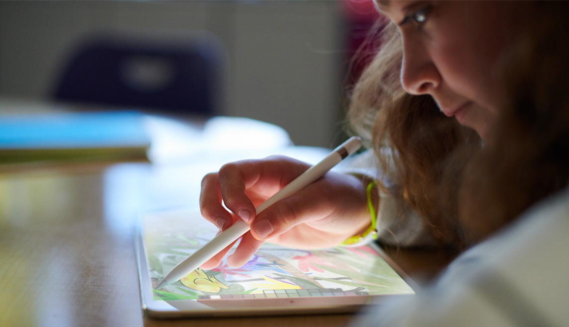 Seorang gadis muda menggunakan Apple iPad dengan Apple Pencil