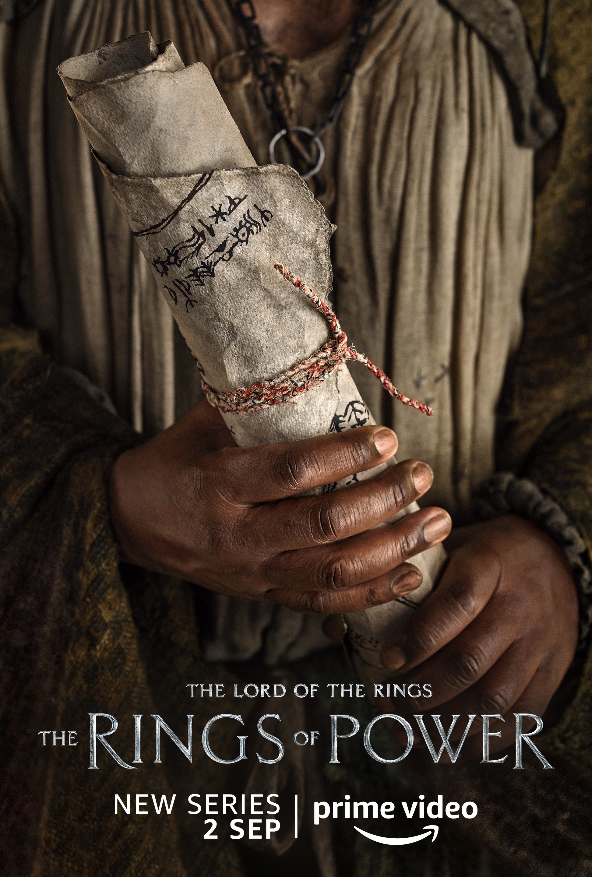 A person holding a map character poster for Lord of the Rings: The Rings of Power