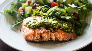 Grilled salmon with pesto and vegetables over the top