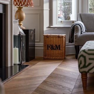 living room wood floor ideas, living room with engineered wood flooring in chevron pattern, basket, stripe sofa, lantern, large table lamp