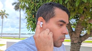 Hero image for best Apple AirPods alternatives showing our reviewer testing the Donner DoBuds One's touch controls