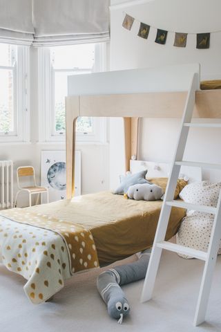 kids bedroom with loft bed and single bed below with ladder and garland on the wall