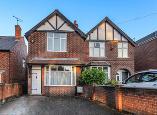 A brick semi detached house with a small front driveway