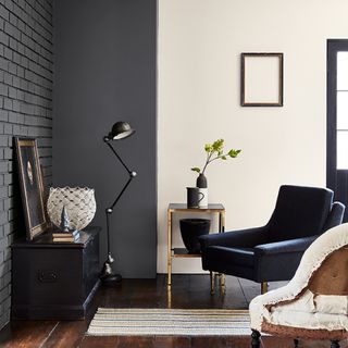 seating area with grey and white wall and wooden floor and blue arm chair
