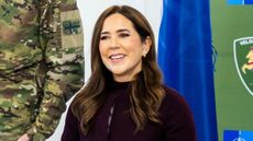 Queen Mary of Denmark smiles as she signs a guestbook during a visit to Adazi Military Base in Adazi, Latvia, on October 29, 2025